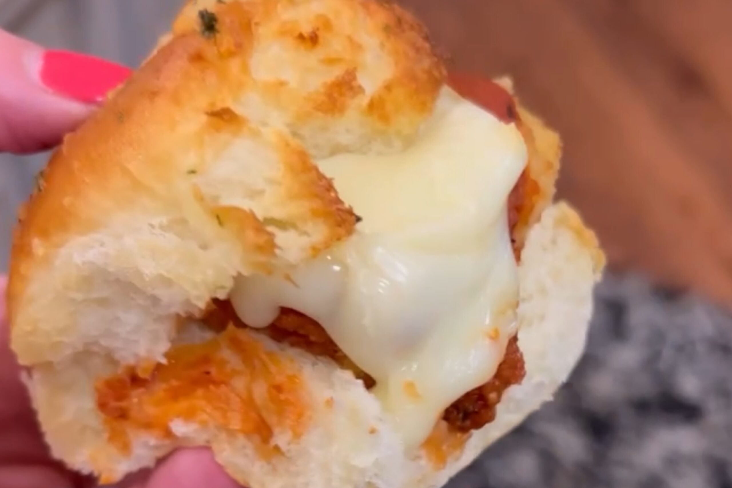 a person holding a Chicken Parmesan Slider